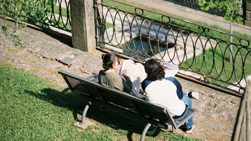 Couple sitting together on a park bench, seen from above