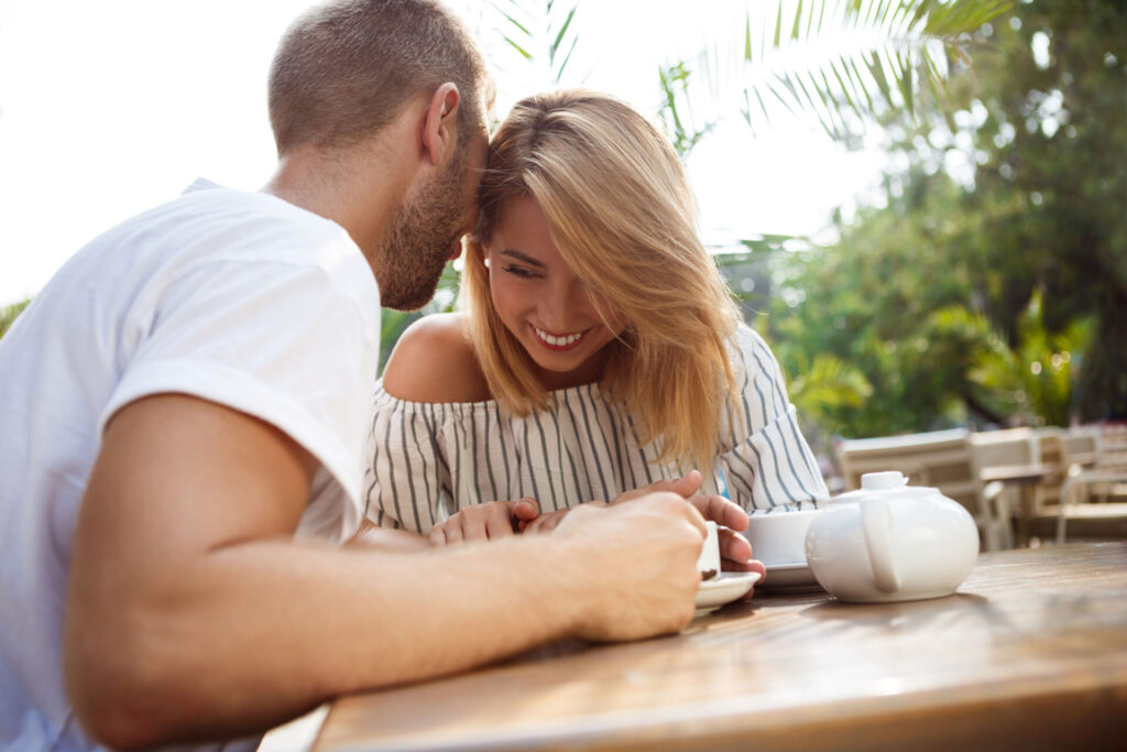 Couple talking closely over coffee at an outdoor table