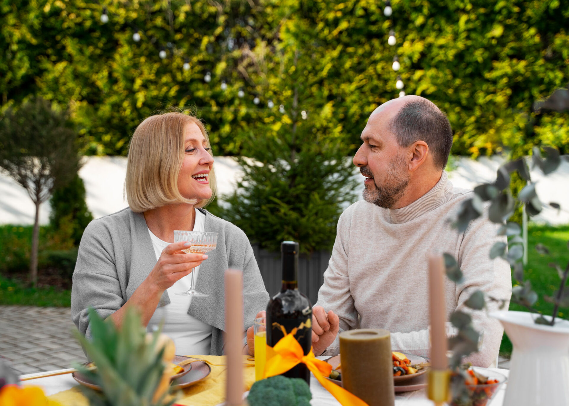 Couple over 50 having dinner together in a garden after meeting on a dating site for seniors