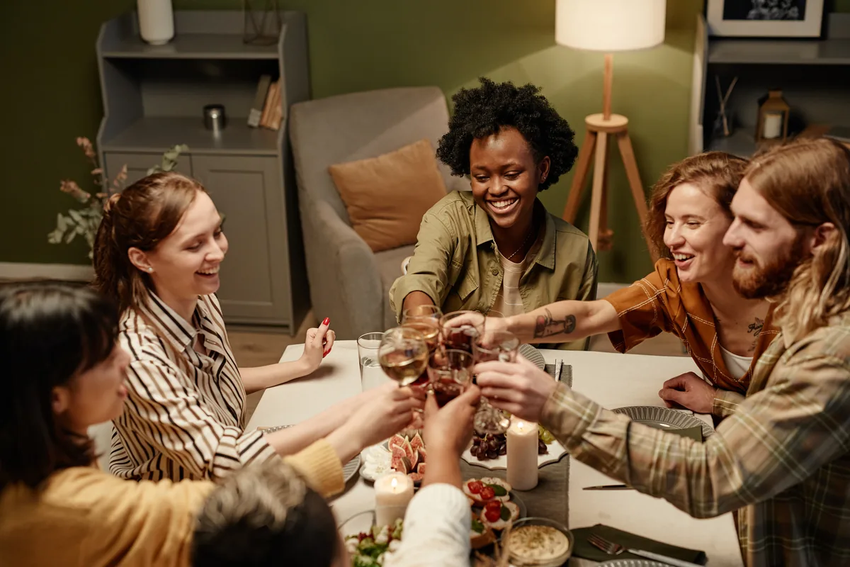 Group of friends raising glasses at a dinner table