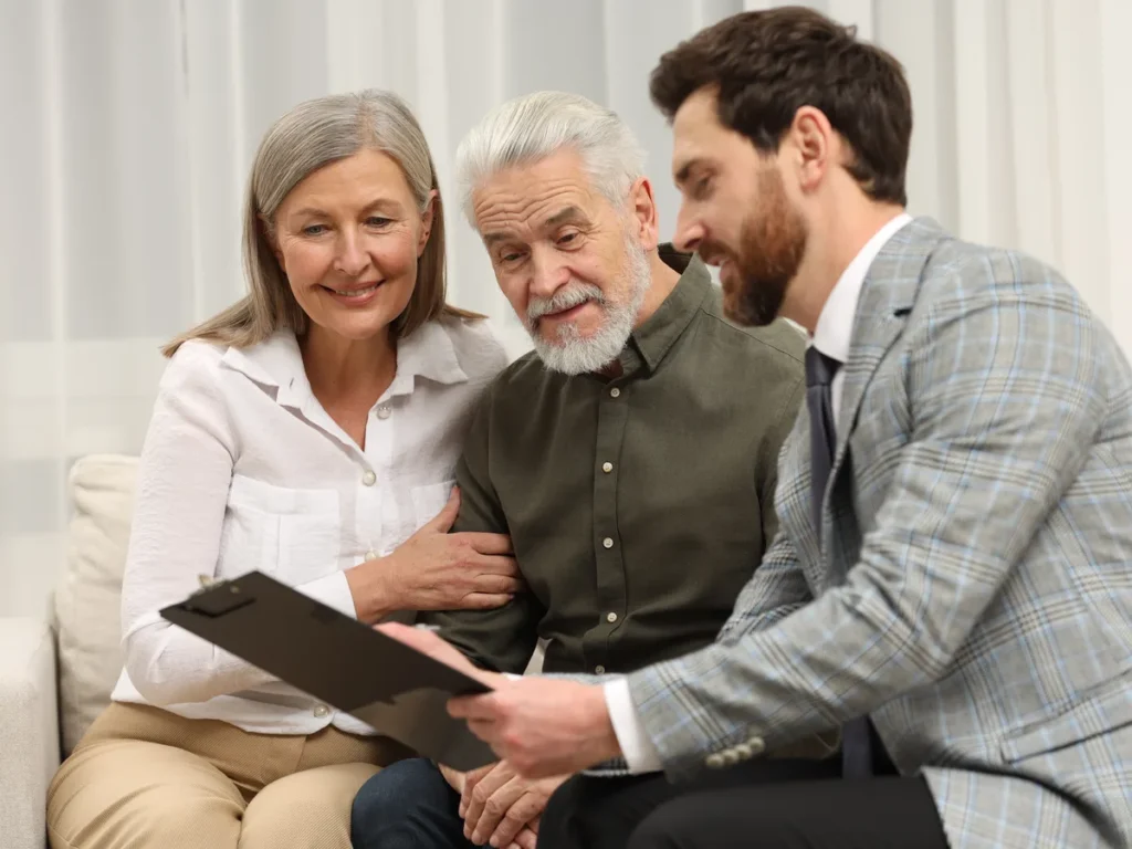 Adviser showing a folder to an older couple on a sofa