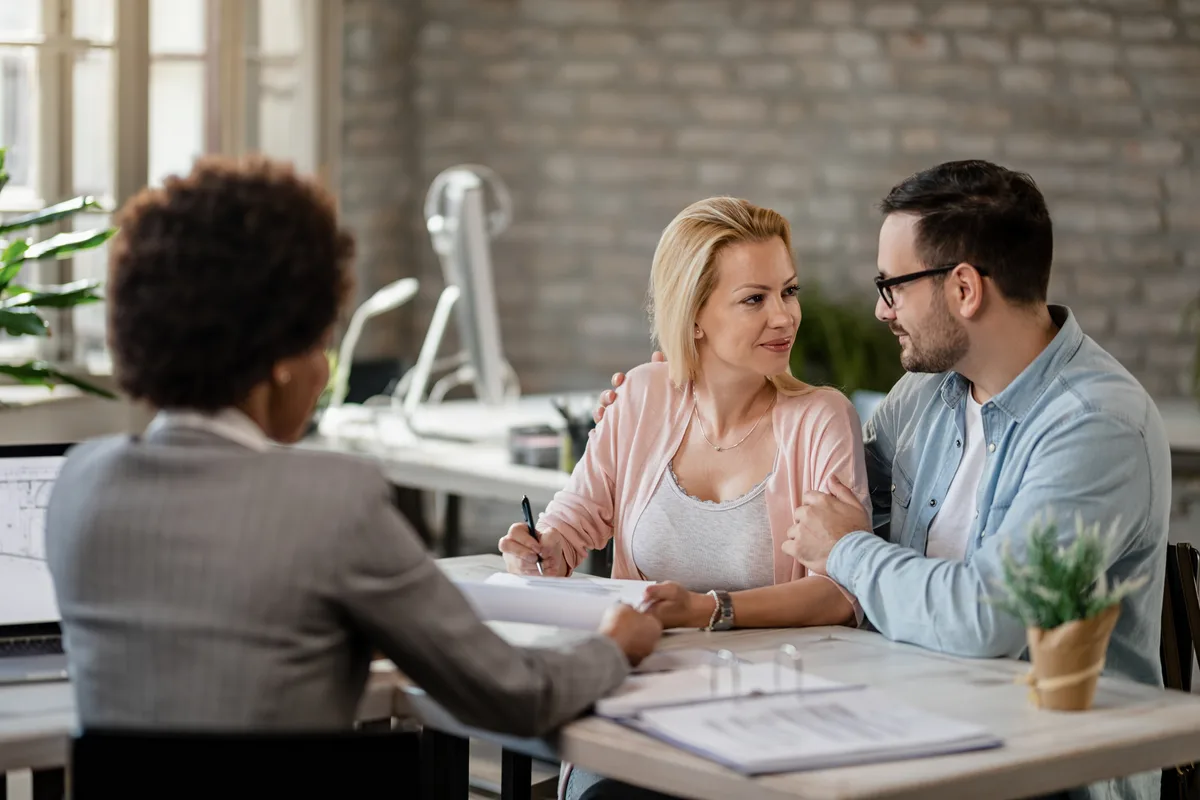 Couple going over documents with an advisor in an office