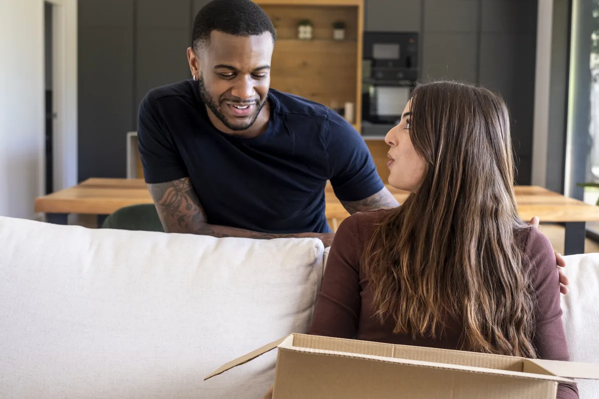 Couple sitting among moving boxes in a new apartment