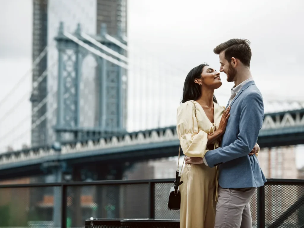 Couple standing on a Brooklyn street with the Manhattan Bridge behind them