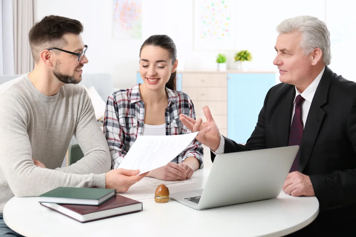 Couple reviewing an agreement with a senior lawyer at a round table