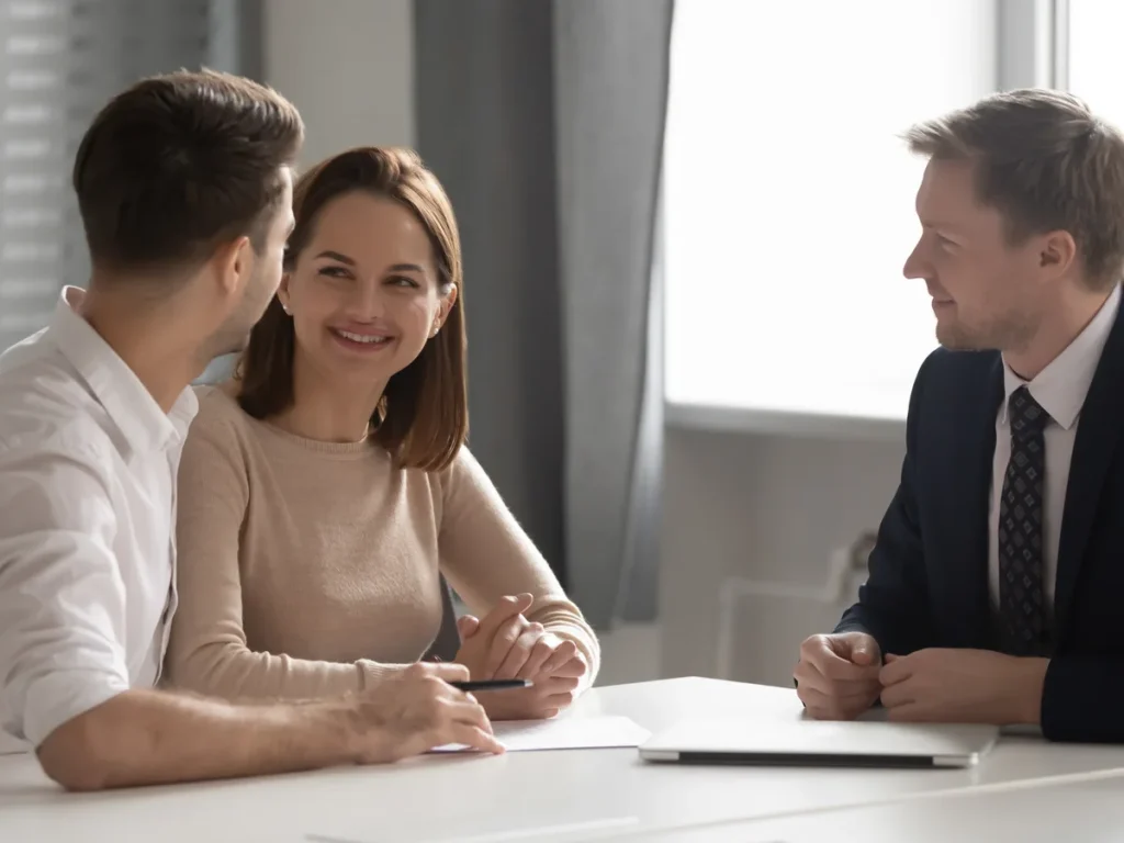Couple reviewing documents with an attorney at a desk