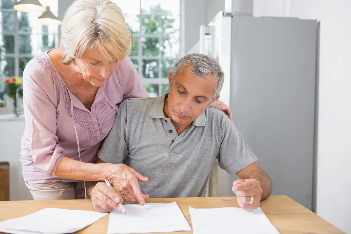 Couple reviewing paperwork together at a kitchen table