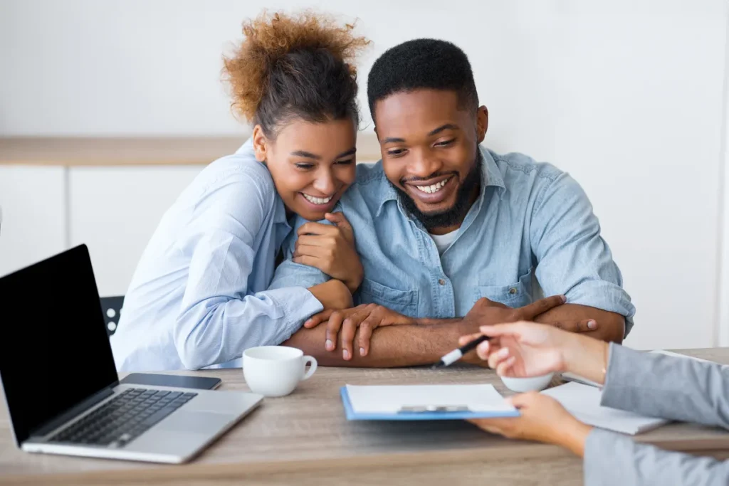 Couple reviewing an agreement together at a table with a laptop