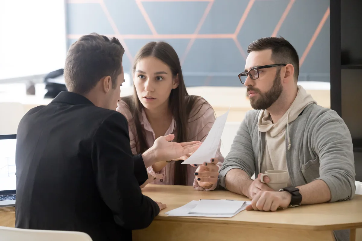 Couple talking with a lawyer across a desk
