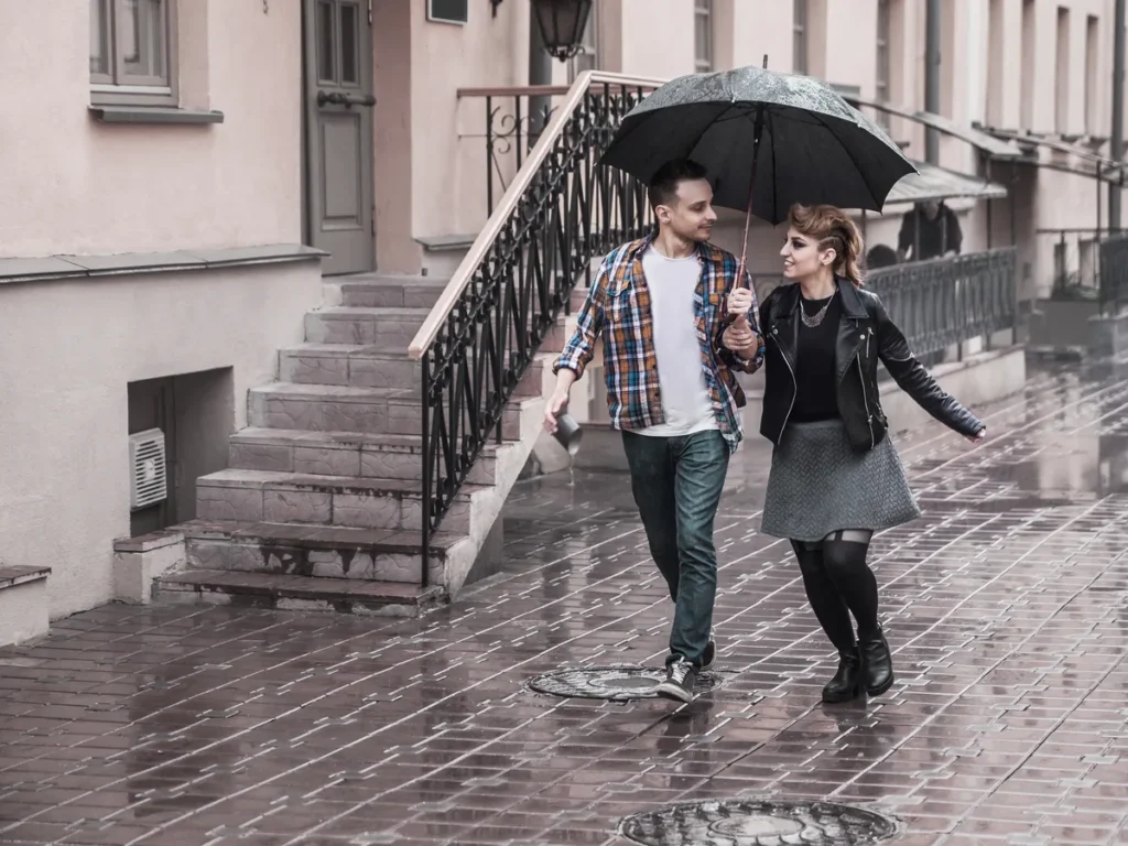 Couple sharing an umbrella on a rainy city street