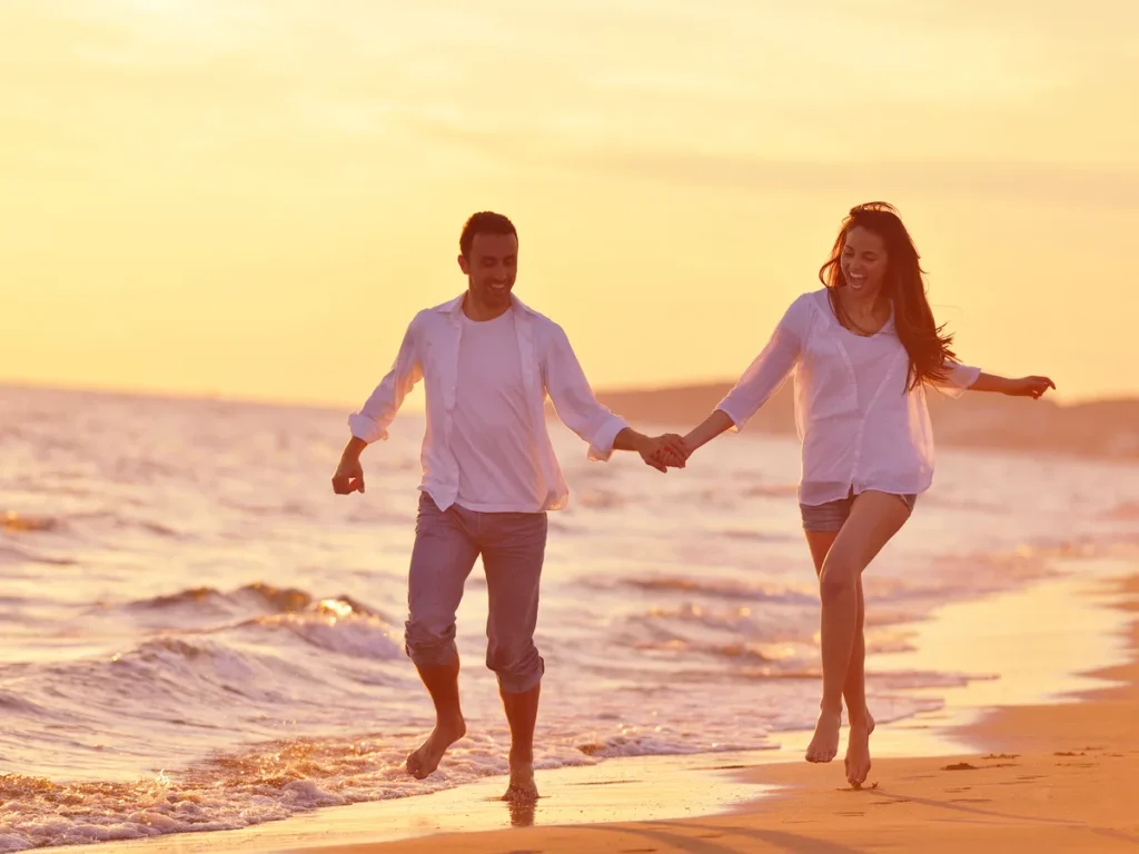 Couple walking hand in hand along the shoreline