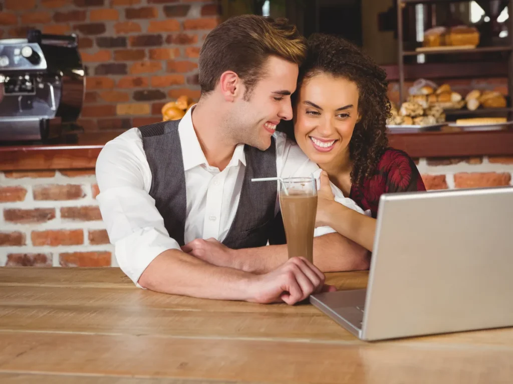 Couple working together on a laptop in a cafe
