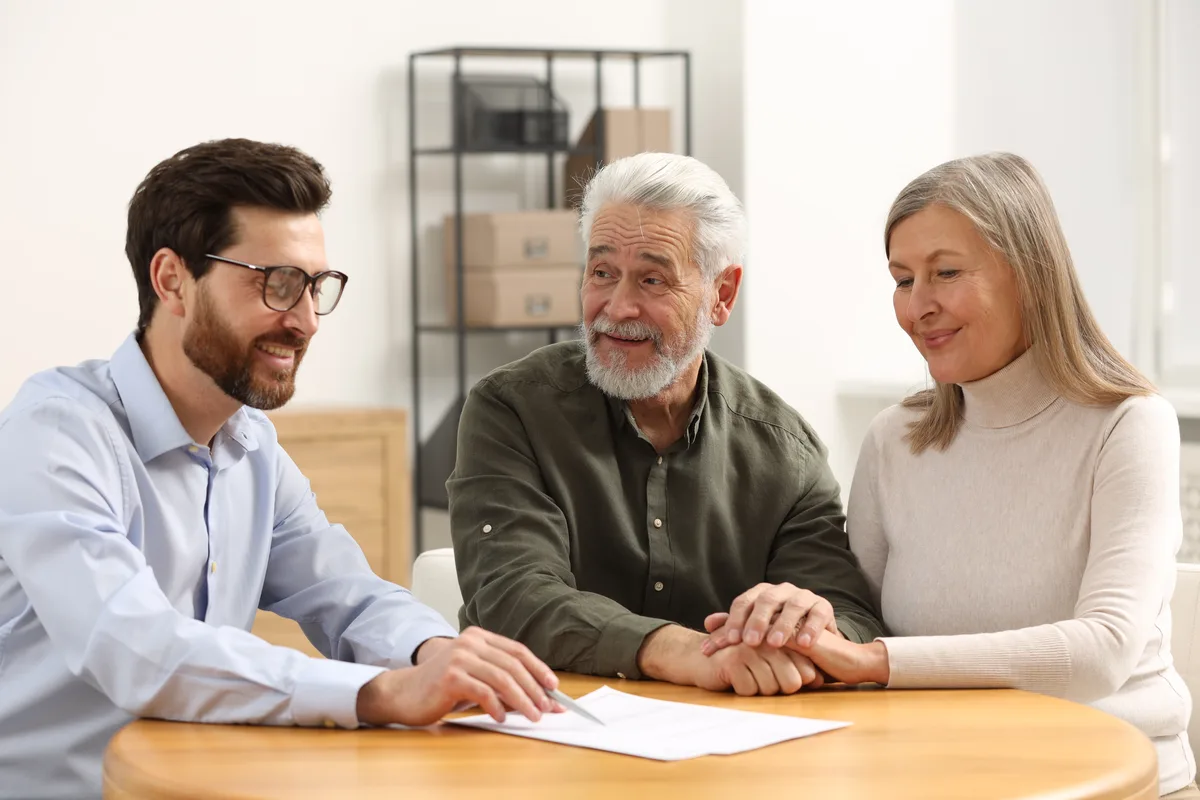 Older couple holding hands during a consultation with an adviser
